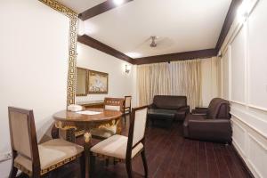 una sala de estar con una mesa y sillas en FabHotel NFC Royale, en Nueva Delhi
