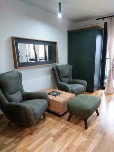 a living room with two chairs and a coffee table at Jagodina studio CRNJANSKI in Jagodina