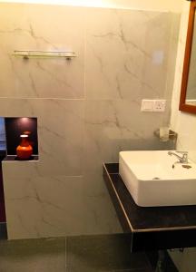 a bathroom with a sink and a vase on a counter at Crystal Waters in Habaraduwa