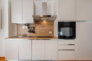 Siera View Apartment - Comfort e Relax a Sappada في سابادا: مطبخ أبيض مع دواليب بيضاء ومغسلة +26 صورة