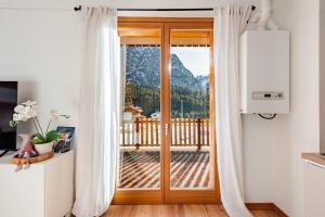 Siera View Apartment - Comfort e Relax a Sappada في سابادا: باب على شرفة مطلة على جبل