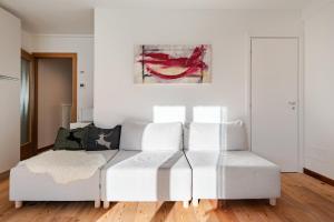 Siera View Apartment - Comfort e Relax a Sappada في سابادا: غرفة معيشة بها أريكة بيضاء و لوحة