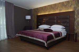 a bedroom with a large bed with purple sheets and pillows at National Park Hotel & Spa in Cotronei +48 photos