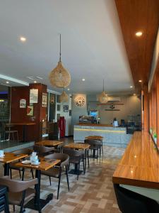 a restaurant with wooden tables and chairs and a bar at Hotel 88 Jember By WH - Strategic Location In The City Center in Jember