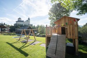 a playground with a wooden play structure in a park at Ferienhaus zur Hackenschmiede in Mauterndorf