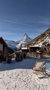 un pendio innevato con una montagna sullo sfondo di Alpine Woodhouse a Valtournenche