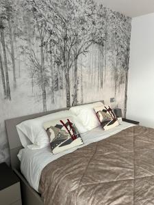 een slaapkamer met een groot bed met bomen aan de muur bij Bormio365 Chalet in Valdisotto