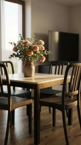 een houten tafel met een vaas met bloemen erop bij Bormio365 Chalet in Valdisotto +39 foto's