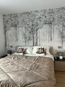 een slaapkamer met een groot bed met bomen aan de muur bij Bormio365 Chalet in Valdisotto