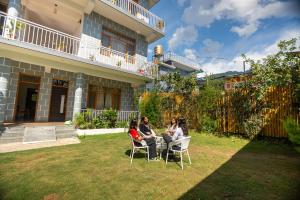 a group of people sitting around a table in a yard at TLO - The Life Outdoor, Bir Billing in Bīr +116 photos