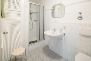 un bagno bianco con lavandino e doccia di Haus Sanderling Meeresbrise a Loog