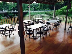 a group of tables and chairs on a wooden deck at Ranong Resort & Laguna in Ban Samnak