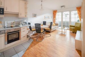una cucina e un soggiorno con tavolo e sedie di Haus Sanderling Meeresbrise a Loog Altre 8 foto
