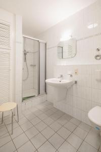 un bagno bianco con lavandino e doccia di Haus Sanderling Meeresbrise a Loog