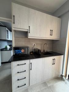 Una cocina con gabinetes blancos y un fregadero. en Boldmark Apartments, en Addis Ababa