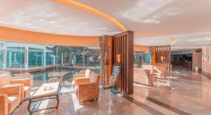 a lobby with chairs and a pool in a building at Huangshan Shuguang Yusong Hotel in Huangshan