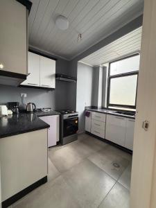 Una cocina grande con gabinetes blancos y una ventana. en Boldmark Apartments, en Addis Ababa 15 fotos más