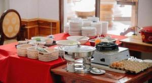 a table with plates and dishes on a red table cloth at Roung Nakhone Vang Vieng Hotel in Vang Vieng