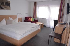 pokój hotelowy z łóżkiem i krzesłem w obiekcie Hotel Garni Sport Sonneck w mieście Galtür
