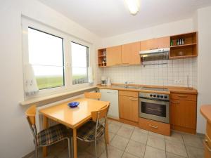 a kitchen with a wooden table and a table and chairs at Haus Nixe Kachelot in Juist