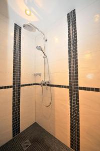 a bathroom with a shower with black and white tiles at ENA Ferien Strandhütte in Juist