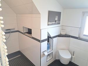 a white bathroom with a toilet and a window at ENA Ferien Strandloft in Juist +10 photos