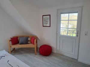 a room with a bed and a chair and a window at ENA Ferien Strandloft in Juist