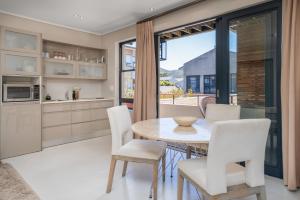 a kitchen and dining room with a table and chairs at The gallery luxury one bedroom apartment unit 101 in Knysna