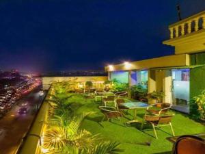 a balcony of a building with chairs and trees at Grand Dhaka Hotel in Dhaka