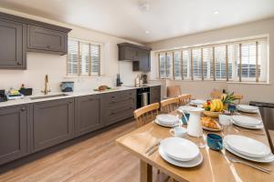 a kitchen and dining room with a wooden table at Garsington Studios Chilterns Farm House - Pass the Keys in Stokenchurch