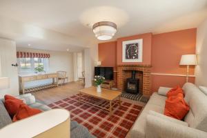 a living room with a couch and a fireplace at Garsington Studios Chilterns Farm House - Pass the Keys in Stokenchurch