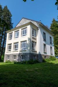 Chambre Perce-Neige, Les Roches Fleuries في Sapois: مبنى أبيض كبير على ميدان عشبي