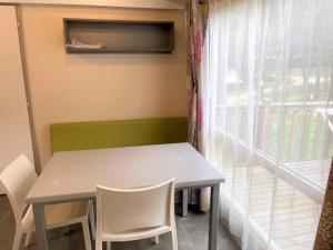 a table and chairs in a room with a window at ZEcamping 3 étoiles chiens acceptés piscine et bar restaurant in Sartène