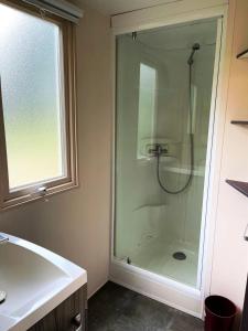 a bathroom with a shower with a glass door at Camping 3 étoiles - Piscine - ccbccbe in Sartène