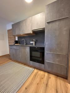 a kitchen with stainless steel appliances and a wooden floor at Höller's Bergleben in Kleinarl