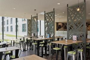 a restaurant with tables and chairs and windows at Super 8 by Wyndham Munich City North in Munich