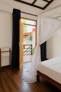 Nisadi Villa في بينتوتا: غرفة نوم بسرير مع ناموسية