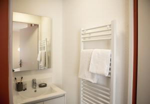 a white bathroom with a sink and a mirror at Sweetly Isatis Mérignac in Mérignac