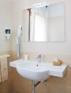 ein Badezimmer mit einem weißen Waschbecken und einem Spiegel in der Unterkunft Hotel Giacomazzo in Caorle