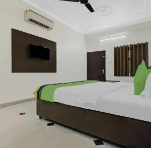 Un dormitorio con una cama y un televisor en la pared. en Jaipur Grand Bella, en Jaipur