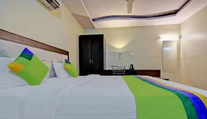 Un dormitorio con una gran cama blanca con almohadas de colores. en Jaipur Grand Bella, en Jaipur 13 fotos más