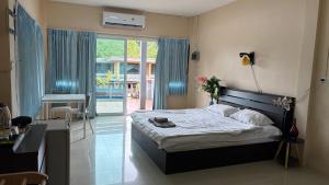een slaapkamer met een bed, een bureau en een raam bij ChefJa Hotel and Restaurant 