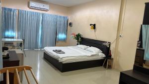 een slaapkamer met een bed, een bureau en een raam bij ChefJa Hotel and Restaurant 