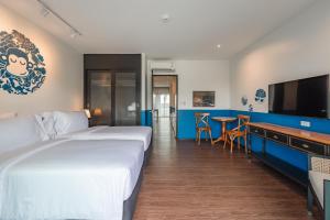 ナイハーンビーチにあるBlu Monkey Boutique Naiharn Beachのベッド2台とバーが備わるホテルルームです。