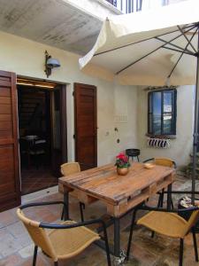 a wooden table with chairs and an umbrella at La Casetta in Penna in Teverina