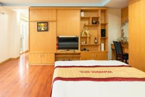 Hoàng Hà Hotel Tam Đảo في تام داو: غرفة نوم بها سرير وتلفزيون في الغرفة