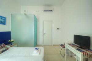 a white room with a bed and a television at Dall'Architetto in Formia