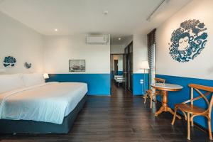 ナイハーンビーチにあるBlu Monkey Boutique Naiharn Beachのベッドとテーブルのあるホテルの部屋