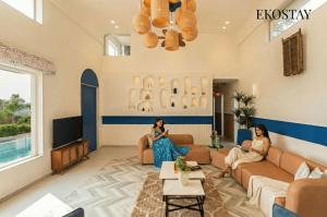 two women sitting in a living room at EKOSTAY Luxe - Hercules Villa in Igatpuri