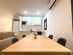 a dining room with a wooden table and chairs at Hauzify I Can Xasil in Blanes